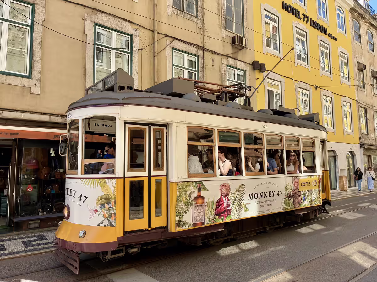 穿行在里斯本老城阿尔法玛区的经典28路黄色有轨电车，葡萄牙旅行的标志性景观。