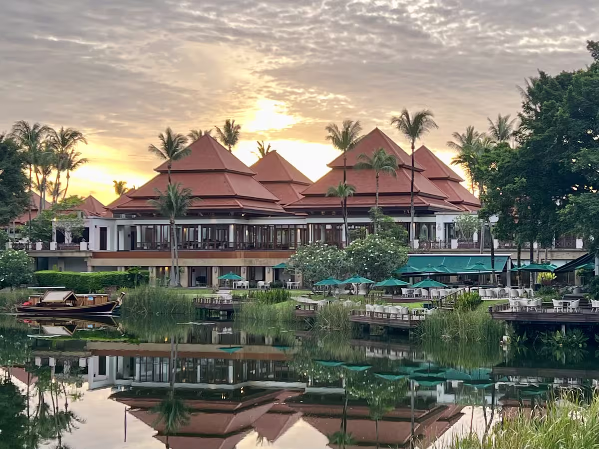 泰国普吉岛的普吉岛悦榕庄 (Banyan Tree Phuket) 度假村的水畔景观餐厅，以其传统的泰式建筑风格、红瓦屋顶和水面美丽的倒影而闻名。