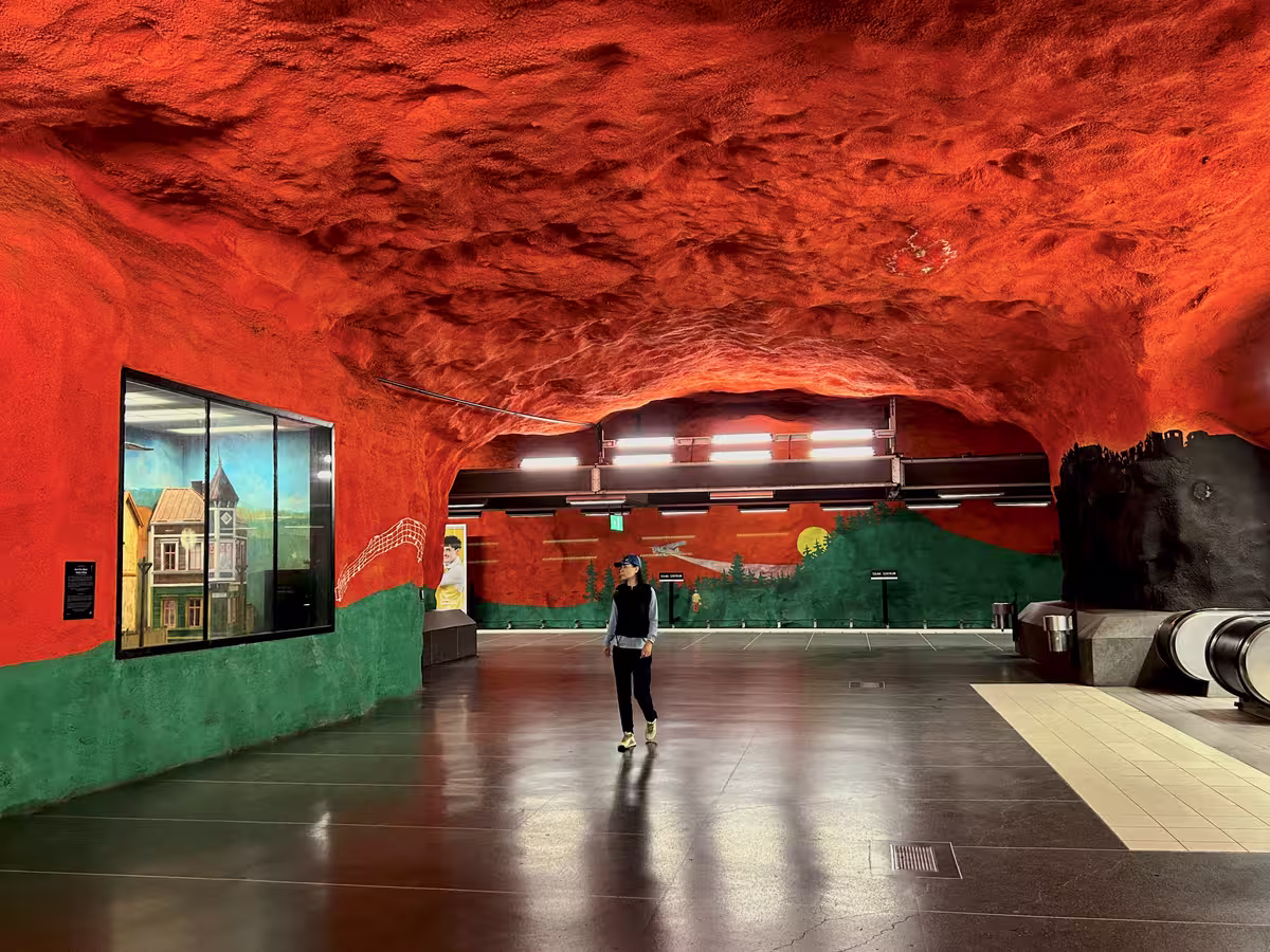 斯德哥尔摩地铁索尔纳中心站 (Solna centrum) 中红色的天空和绿色的云杉林。