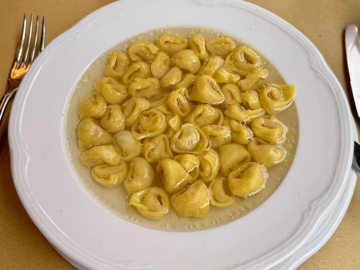 博洛尼亚 (Bologna) 的传统小饺子 (Tortellini)，盛在金色的鸡肉高汤中，饺子个头极小。