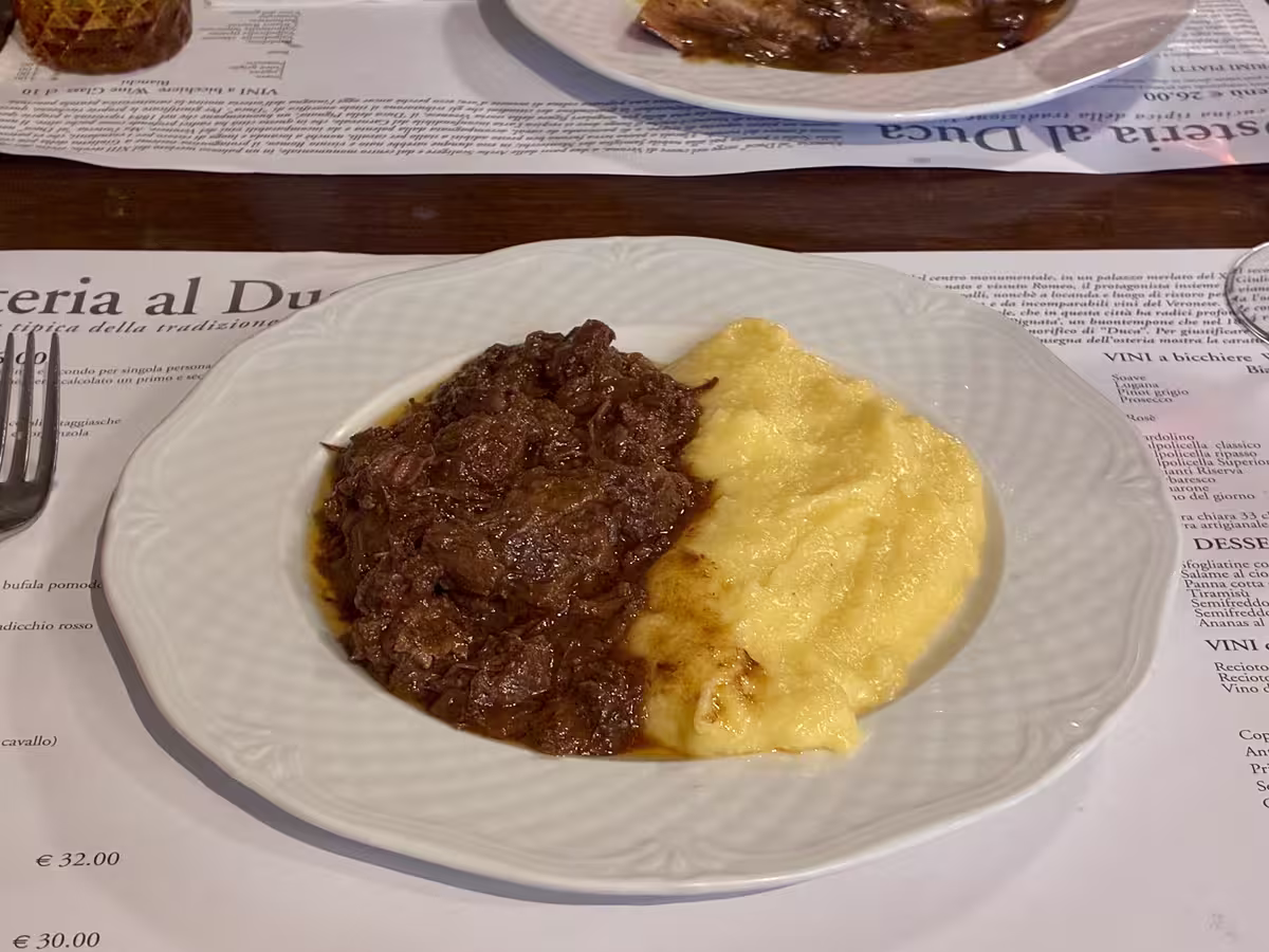 维罗纳公爵酒馆 (Osteria al Duca) 中的红酒慢炖马肉 (Pastissada de Caval) 配玉米糊 (Polenta)。