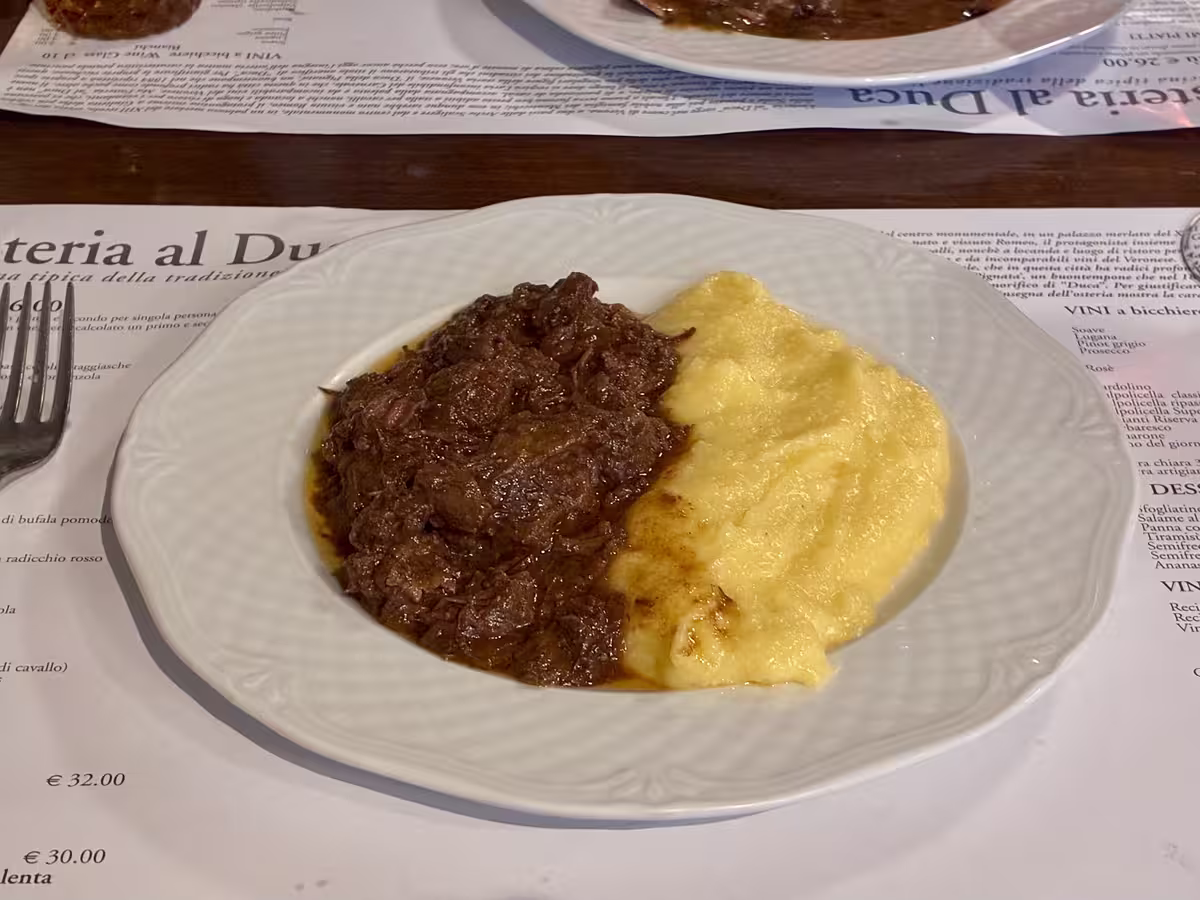 维罗纳公爵酒馆 (Osteria al Duca) 中的红酒慢炖马肉 (Pastissada de Caval) 配玉米糊 (Polenta)。
